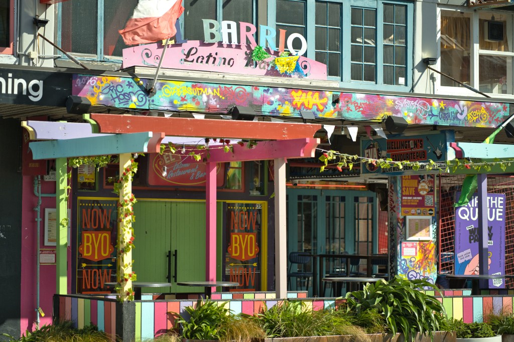 Exterior of Barrio, a colorful Latino restaurant and bar featuring vibrant murals and decorative elements in a lively urban setting.